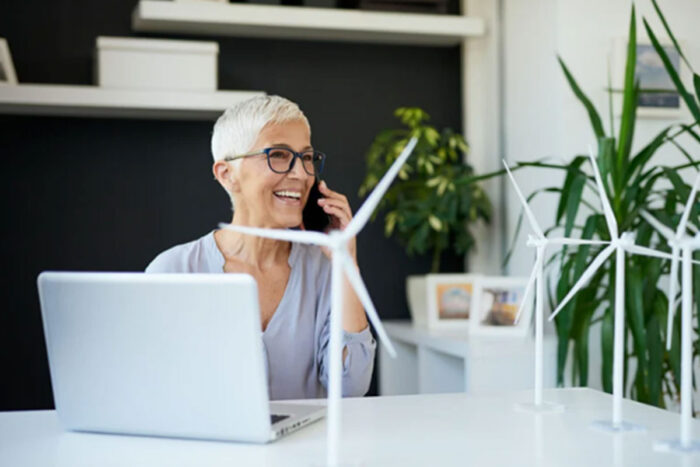 Vrouw achter computer met windmolens op het bureau